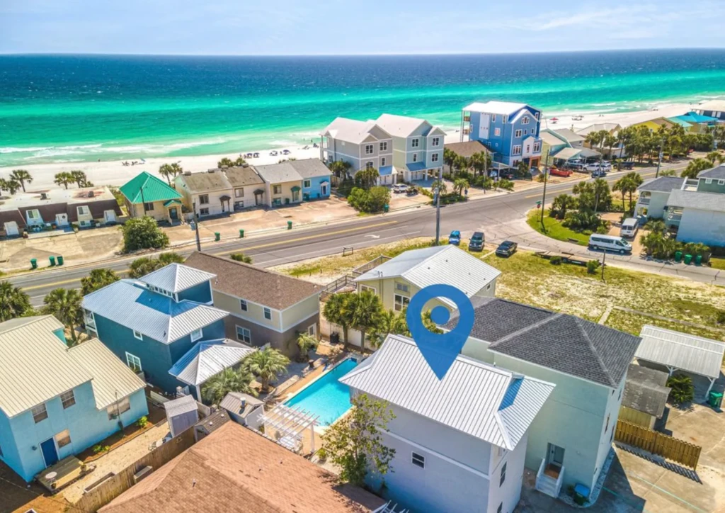 Aerial view of beachfront Panama City Beach house rental with turquoise pool and ocean view