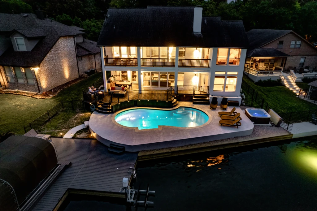 Turquoise swimming pool with deck and river views at luxury vacation rental near Montgomery, TX