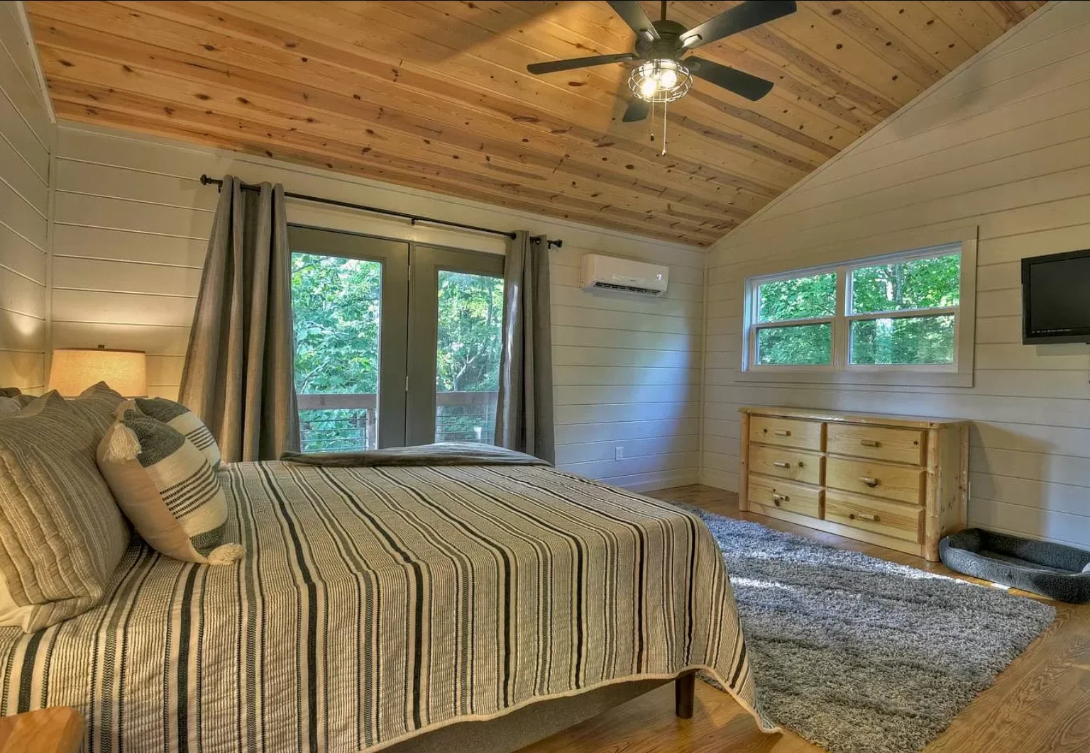 Rustic master bedroom with knotty pine vaulted ceiling, king bed, and mountain views in Blue Ridge