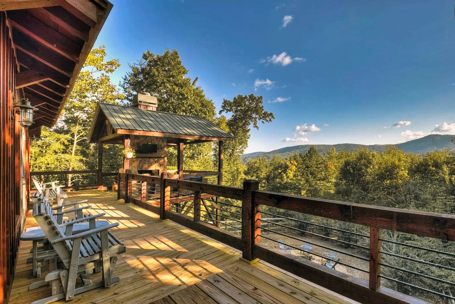 Covered outdoor kitchen gazebo with stone fireplace on a mountain deck with forest views at Chalet Blue Ridge, Blue Ridge GA