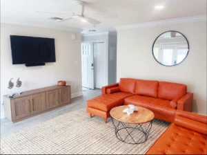 Modern living room with orange sectional sofa at Nest Awaits Panama City Beach alternative rental