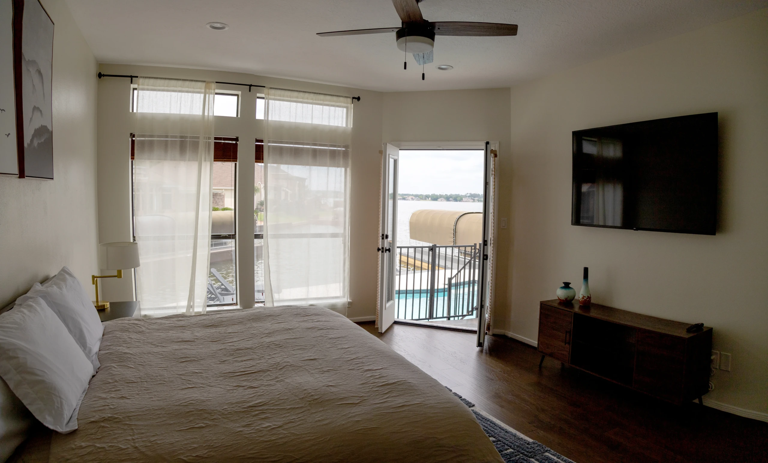 Waterfront master bedroom with queen bed, patio access, and water views at Nest Awaits Montgomery