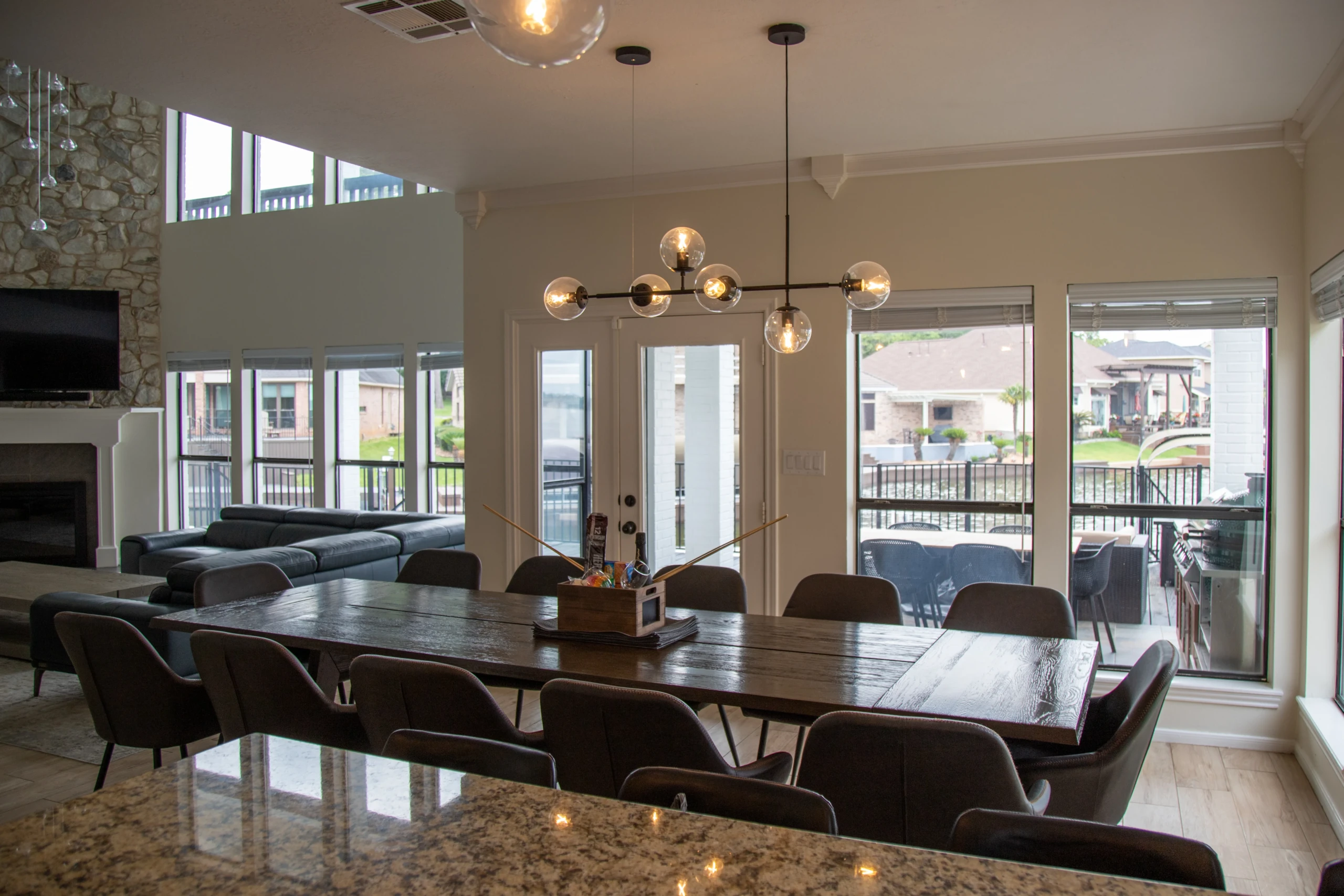 Open dining room with glass doors to the waterfront deck at The Waterfront Villa, Montgomery TX