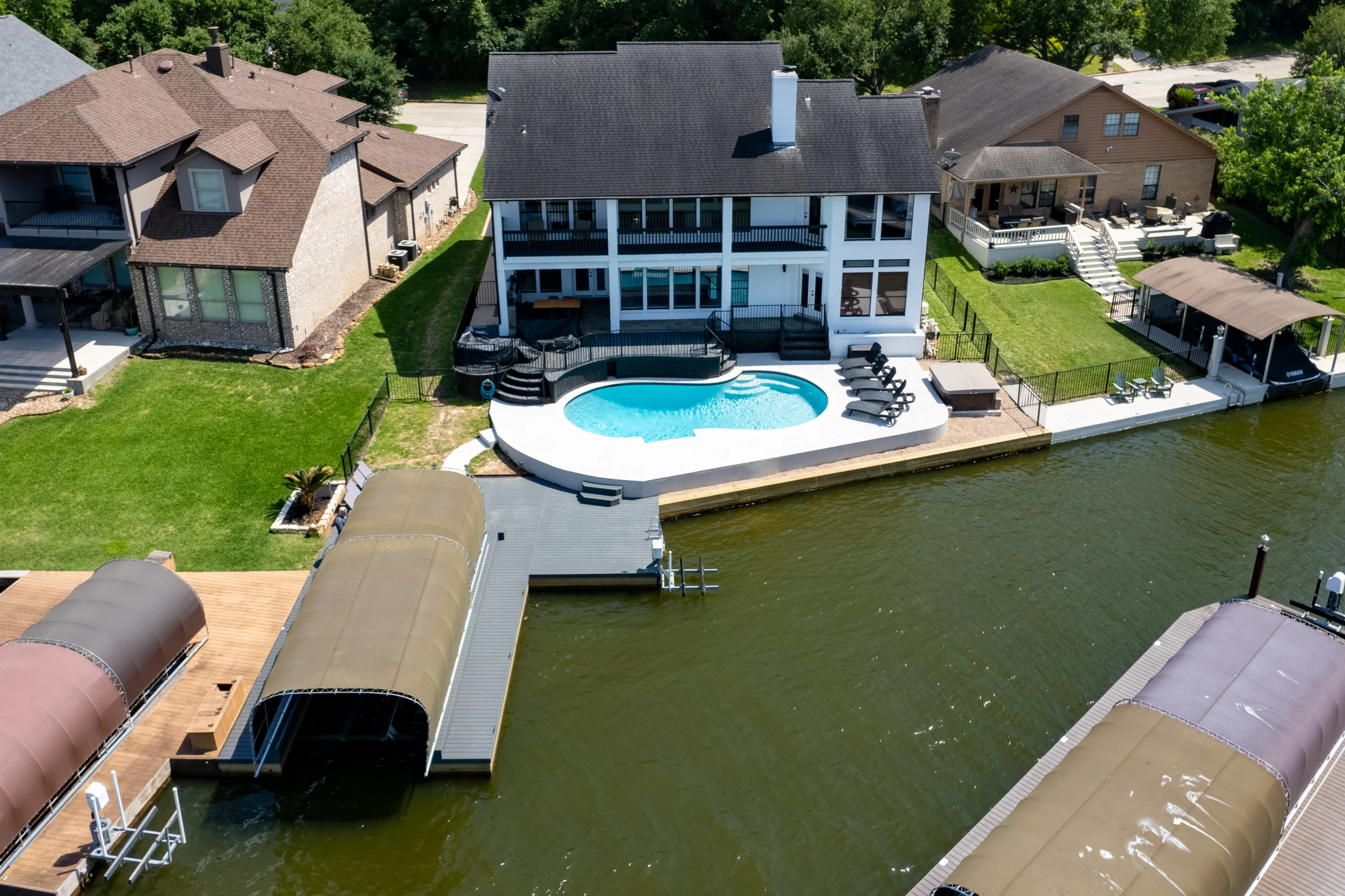 Aerial view of waterfront house with pool and private dock, a top pick for Montgomery vacation rentals
