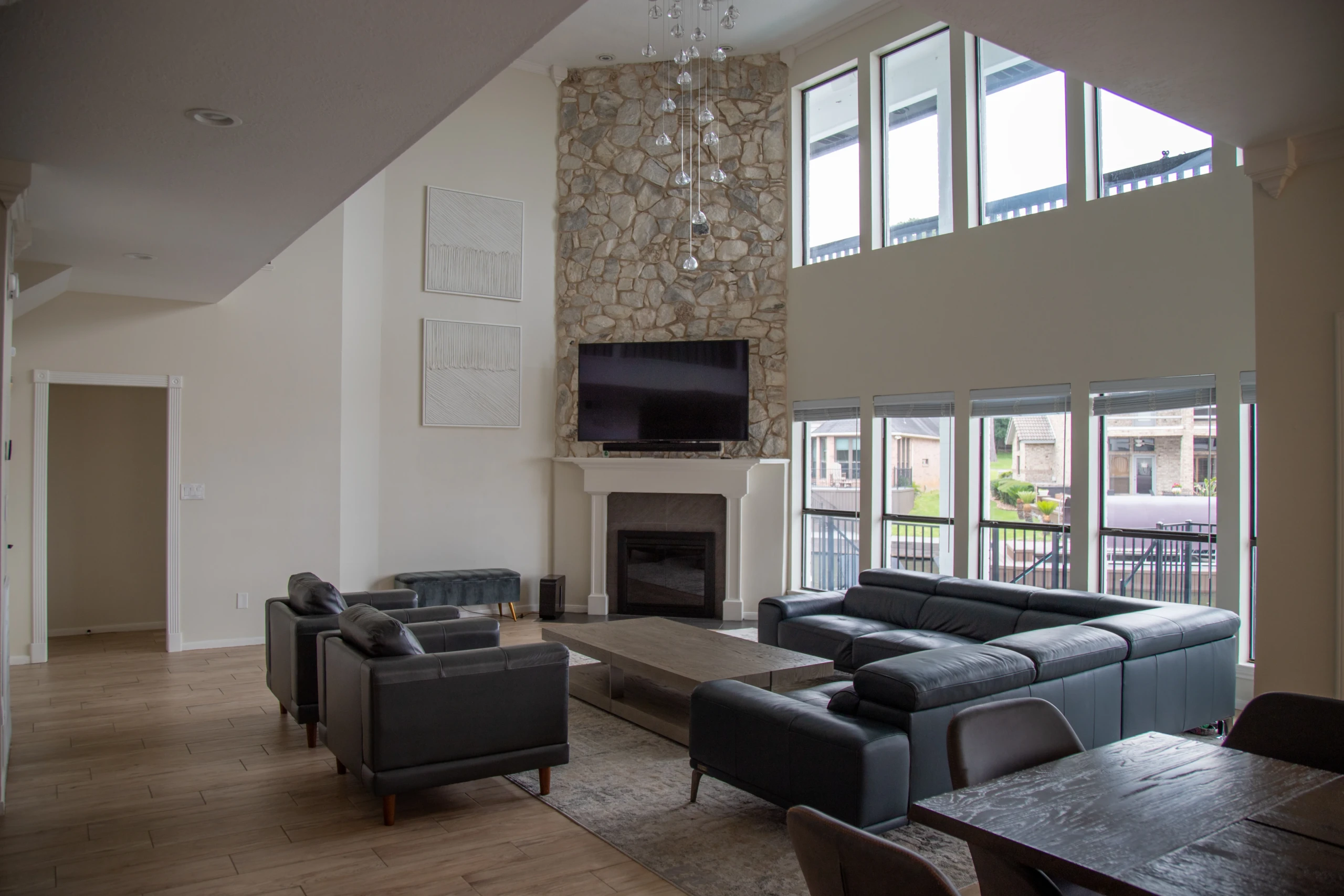Modern living room with stone fireplace and floor-to-ceiling windows in Montgomery TX luxury home