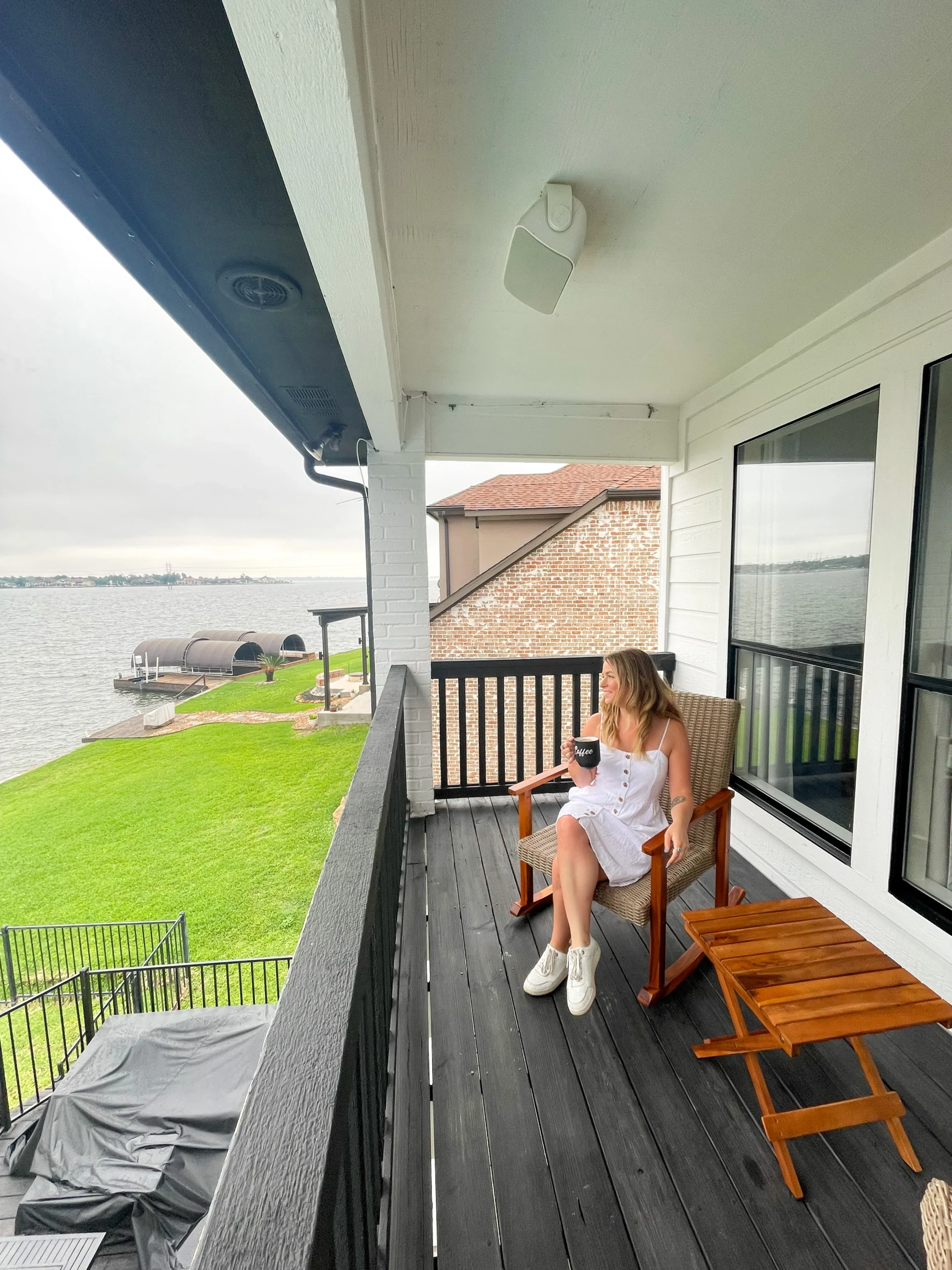 Woman relaxing on patio deck overlooking lake at Montgomery waterfront vacation rental