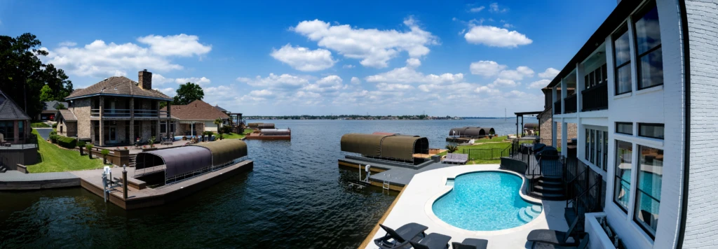Curved turquoise swimming pool with covered boat lifts and bay views at a Blue Ridge cabin with hot tub, Nest Awaits, Blue